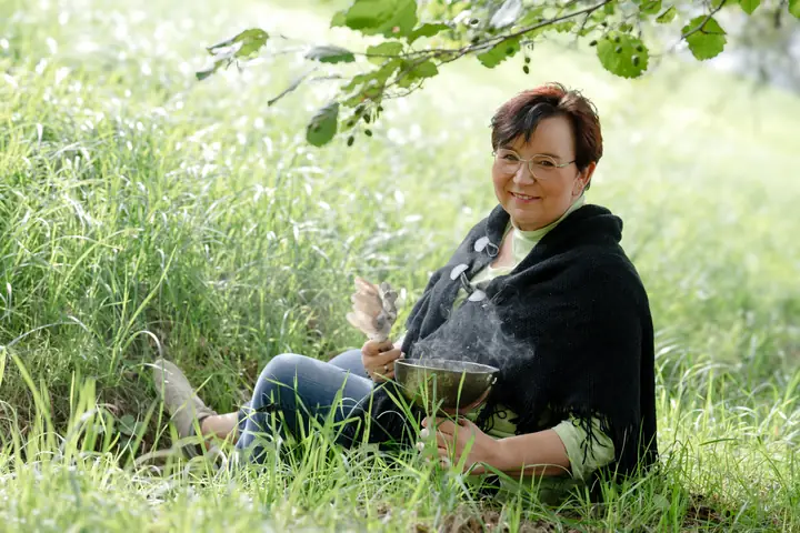Nicole Dreis sitzt mit rauchender Schale im Gras