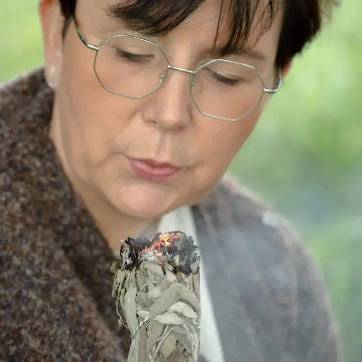 Nicole Dreis bläst die Glut eines Räucherbündels an